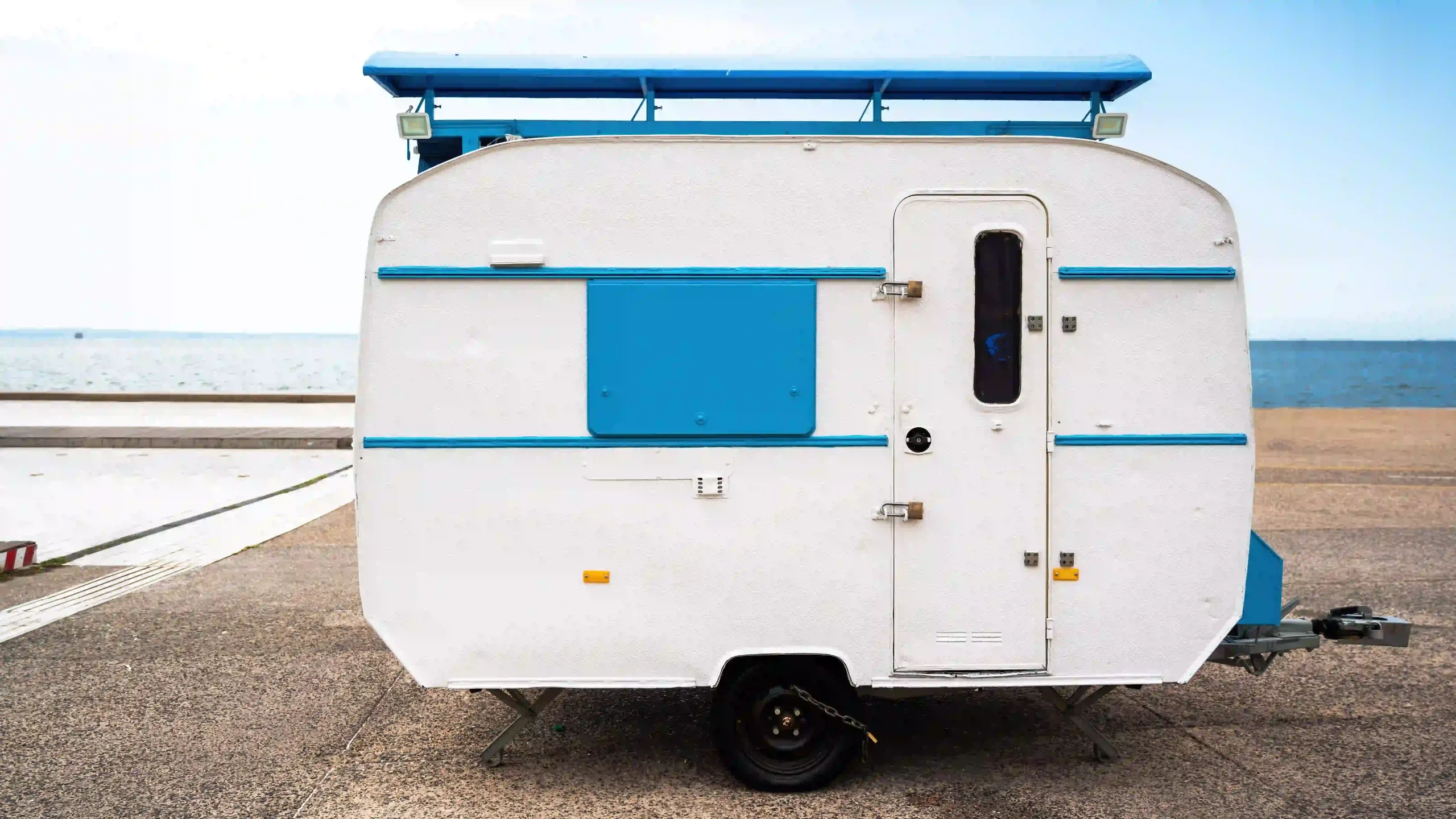 white-blue-travel-trailer-with-sea-background-thessaloniki-greece