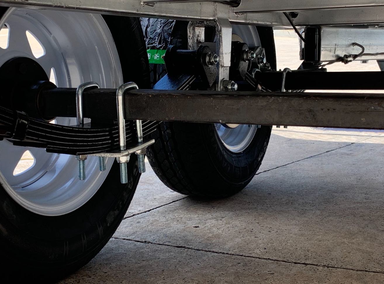 Tandem rocker roller spring system for balanced heavy trailer suspension